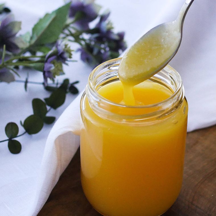 透明な瓶に入ったレモンカードを、スプーンですくっている様子