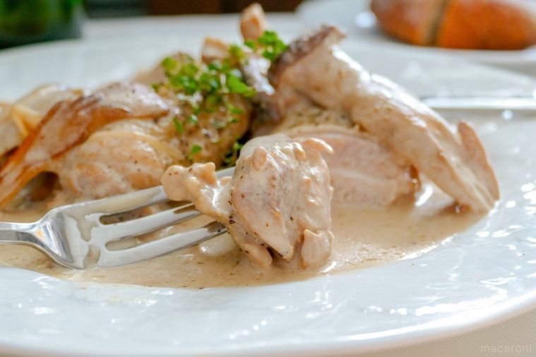 切り分けたチキンフリカッセを刺したフォーク