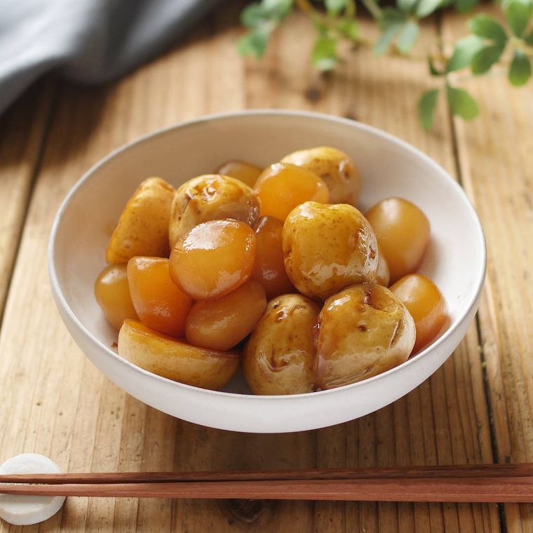 白い皿に盛り付けられた新じゃがとこんにゃくの煮物