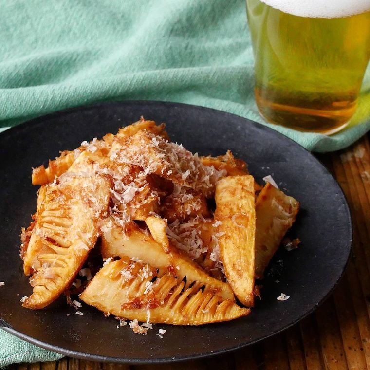 黒い皿に盛り付けたたけのこのおかかバターしょうゆ炒め