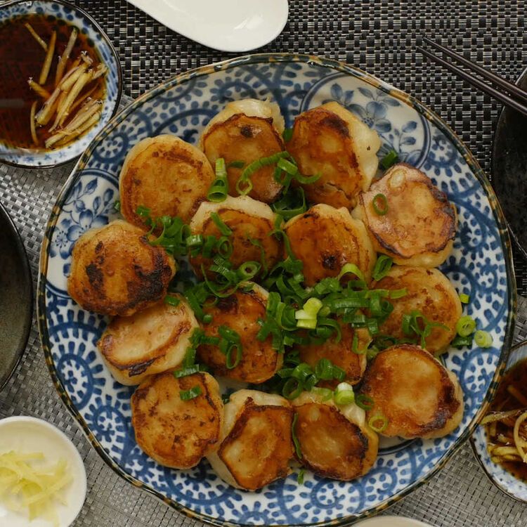 藍色の模様が入った皿に盛られた焼き小籠包