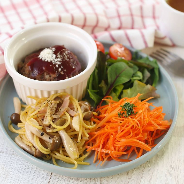 お皿に盛られたきのこパスタ、にんじんサラダ、ココットに入ったハンバーグ