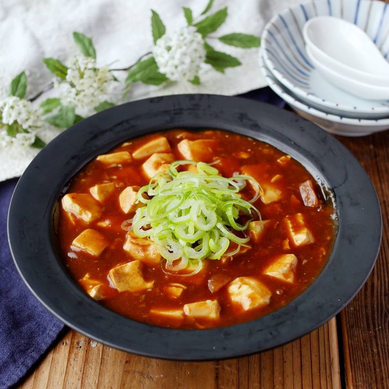 黒いマットな深皿に盛りつけられているカレーのリメイク麻婆豆腐