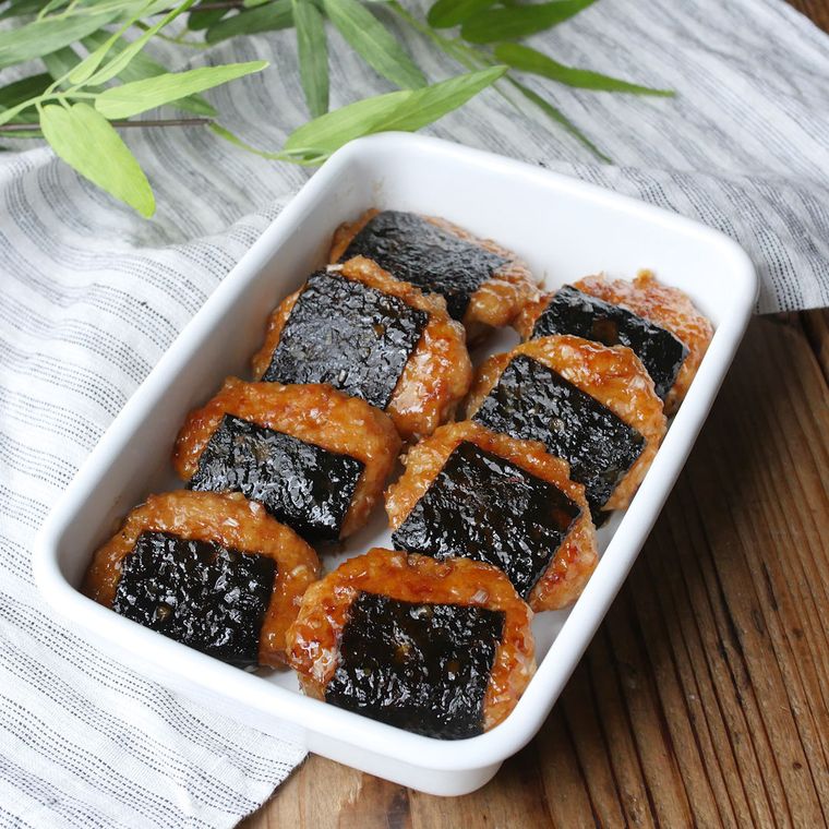 白い保存容器に入っている8個の海苔巻き鶏つくねの照り焼き風