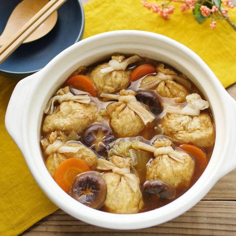 白い土鍋に入っている、油揚げ巾着の白だし鍋