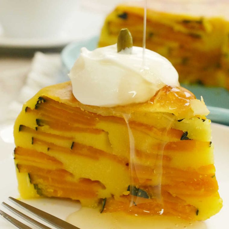 白い皿に盛りつけられたホイップクリームがけかぼちゃケーキ