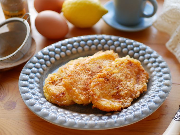 皿にのったレチェ・フリータと、卵、レモン、コーヒーカップ