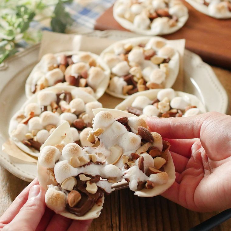 ベージュの皿にのせた餃子の皮でスモアチョコナッツピザ