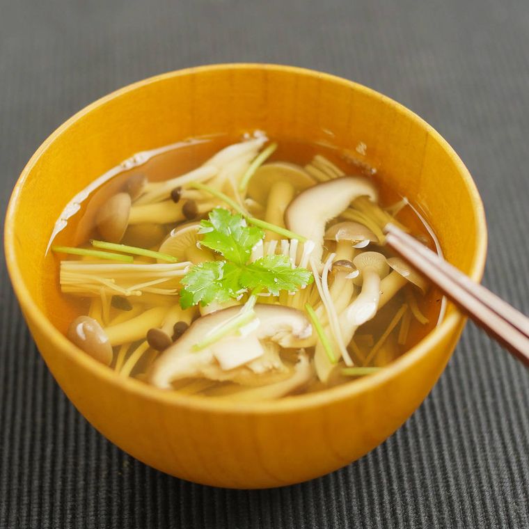 木の器に盛られたたっぷりきのこ汁に箸が添えてある様子