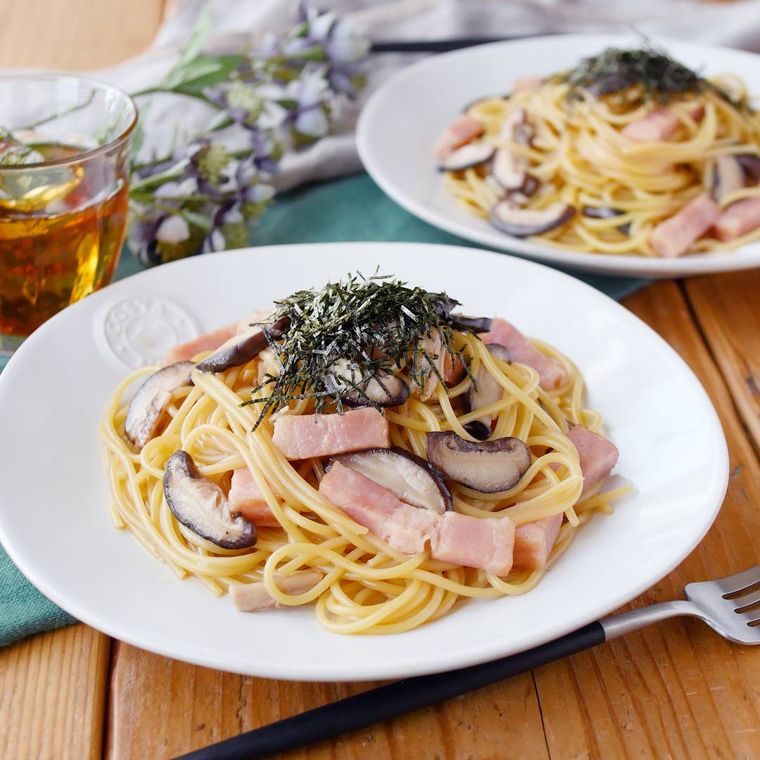 白い皿に盛りつけられたしいたけとベーコンの和風パスタ