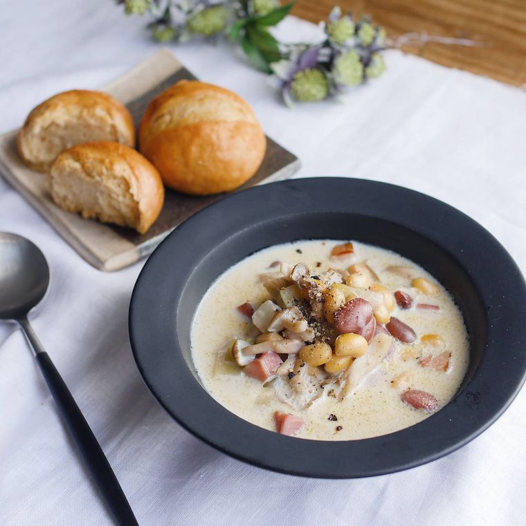 黒いスープ皿に盛られた豆ときのこのクリームスープ