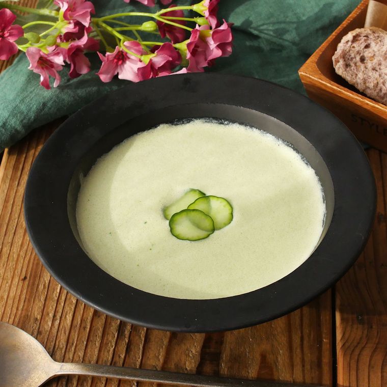 黒いスープ皿に盛られたきゅうりと絹豆腐の冷製クリームスープ