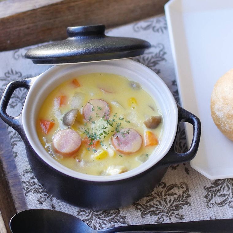 黒い鍋に入っている野菜ときのこのコーンクリームスープ