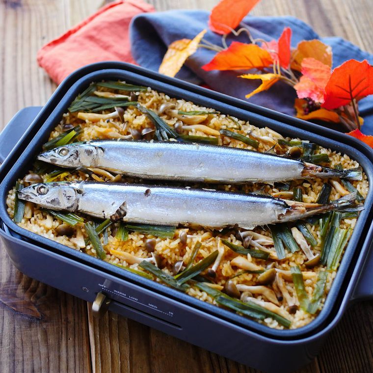 ホットプレートに入っている丸ごと秋刀魚のピリ辛炊き込みごはん