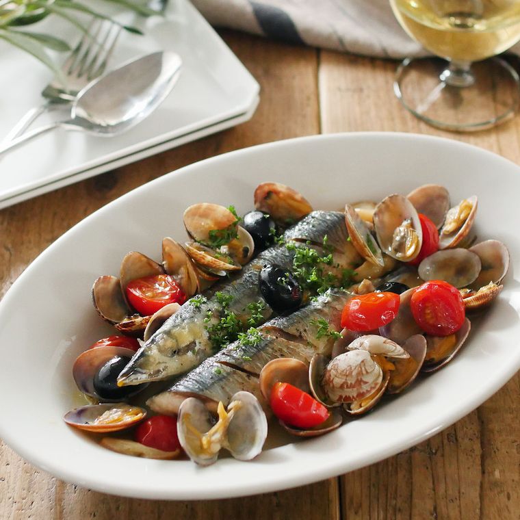 白い長皿に盛りつけられている秋刀魚とあさりのアクアパッツァ