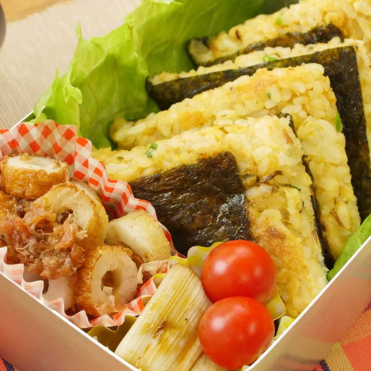 4等分にカットされたごま油香る焼きおにぎらずがお弁当に詰められている画像