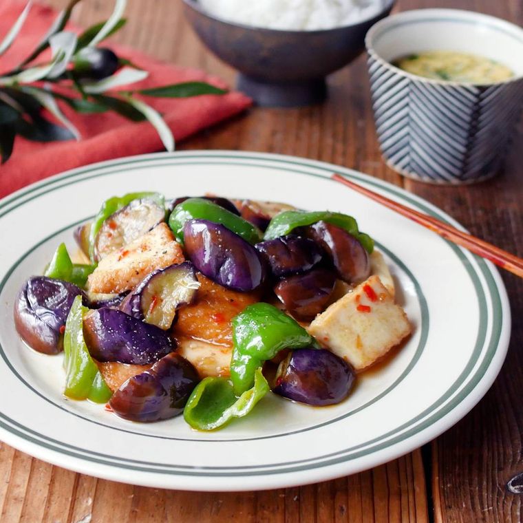 グレーの縁取りの皿に入ったなすとピーマン、厚揚げのスイートチリソース炒め