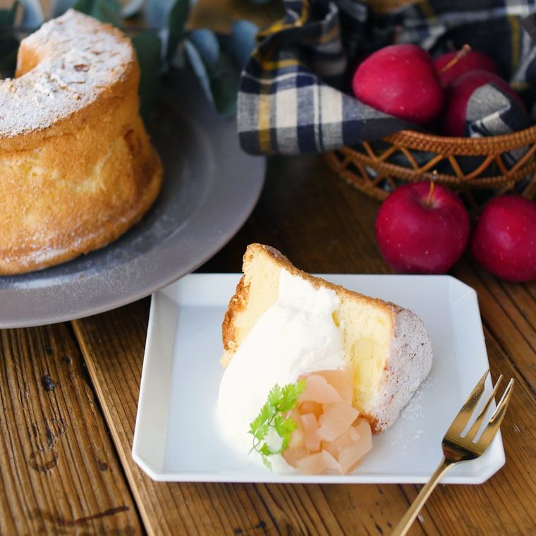 白い皿にカットして盛り、ホイップとりんごのコンポートを添える様子