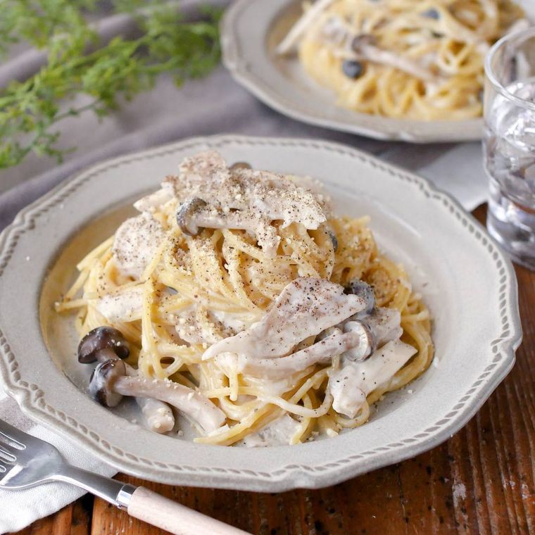 白い皿に盛り付けたきのこたっぷりチーズクリームパスタ
