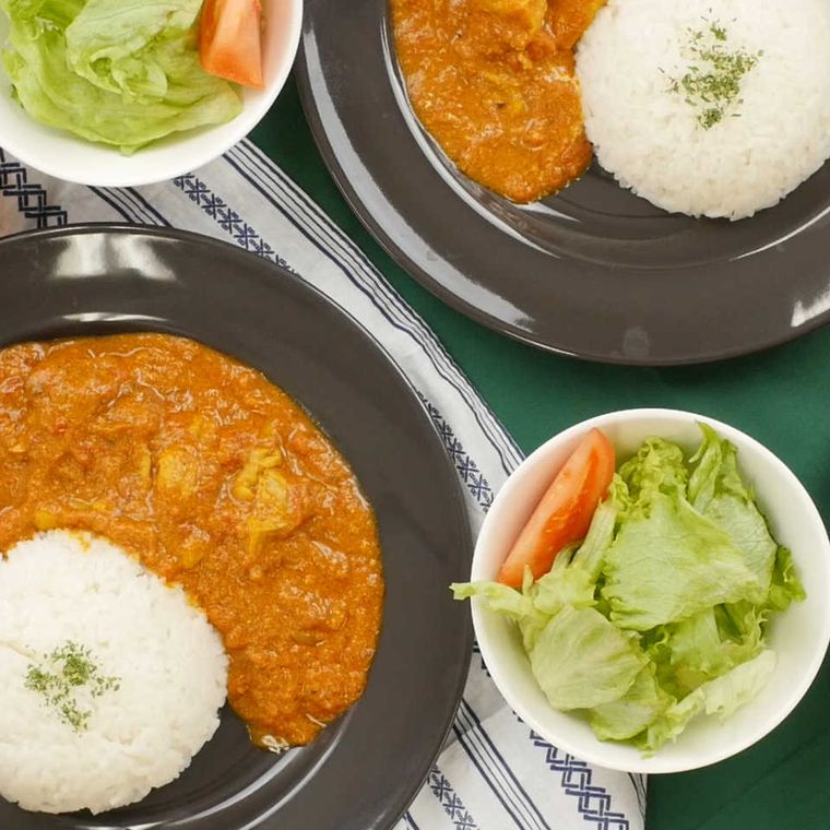 茶色の皿に盛られたカレーライスと白い容器に入ったサラダ