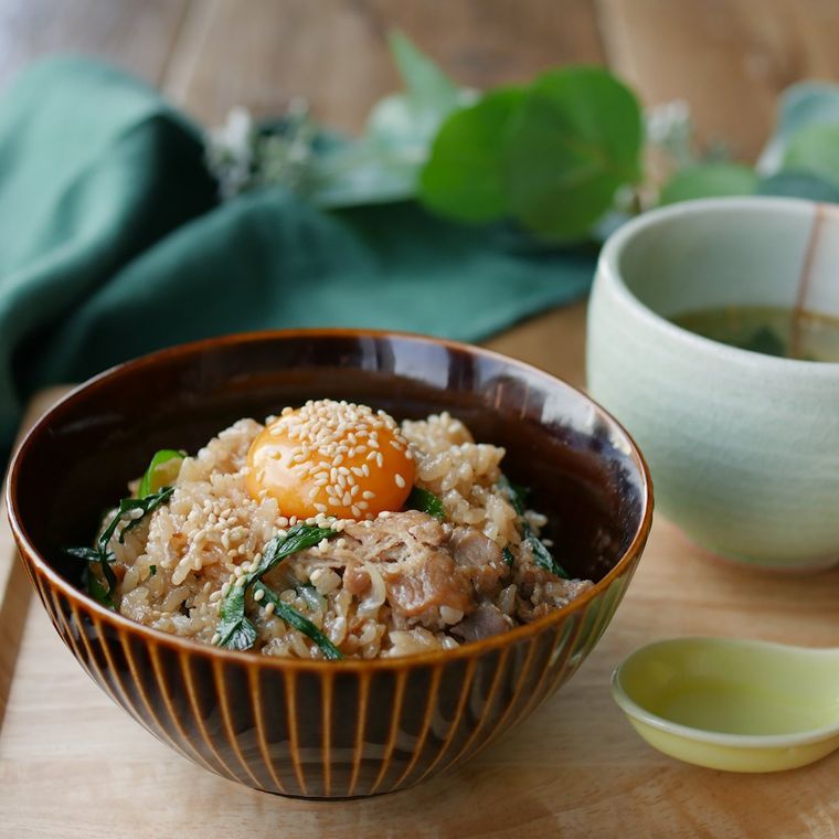 茶色い茶碗に盛られた、ニラ豚炊き込みご飯