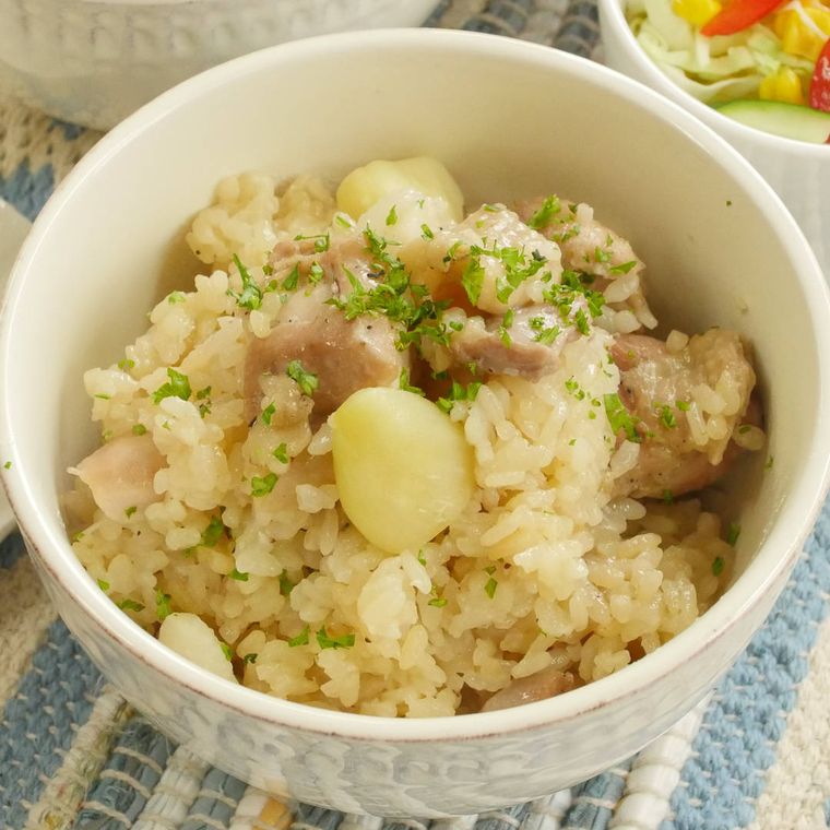 白い器に盛られた、にんにくと鶏肉の炊き込みご飯