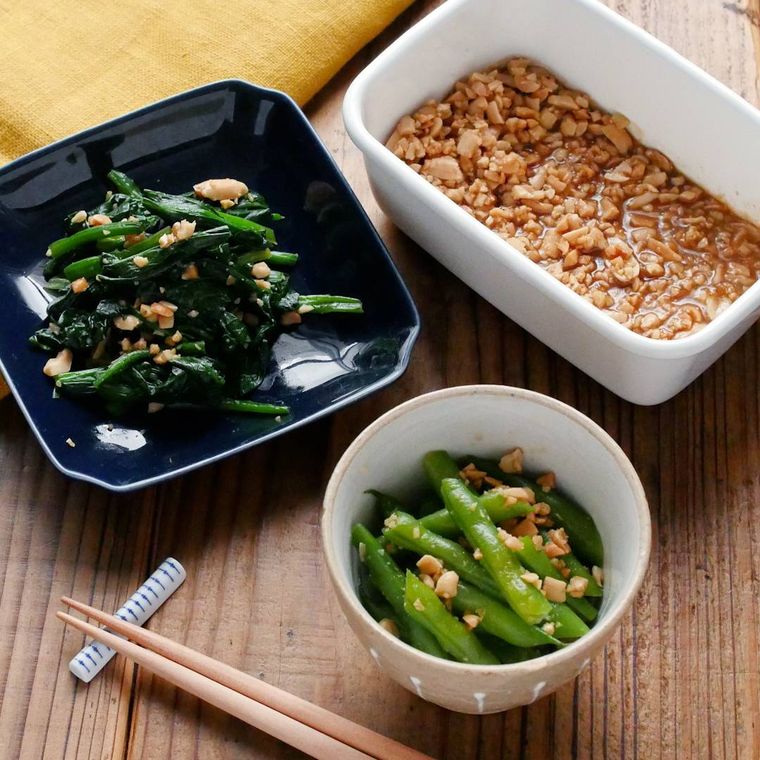 白い保存容器に入ったピーナッツ和えの素と小皿に盛り付けられた野菜のピーナッツ和え