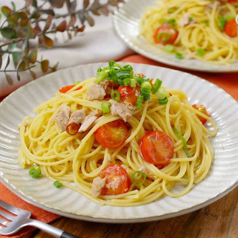 白い丸皿に盛られたミニトマトとツナのペペロンチーノ