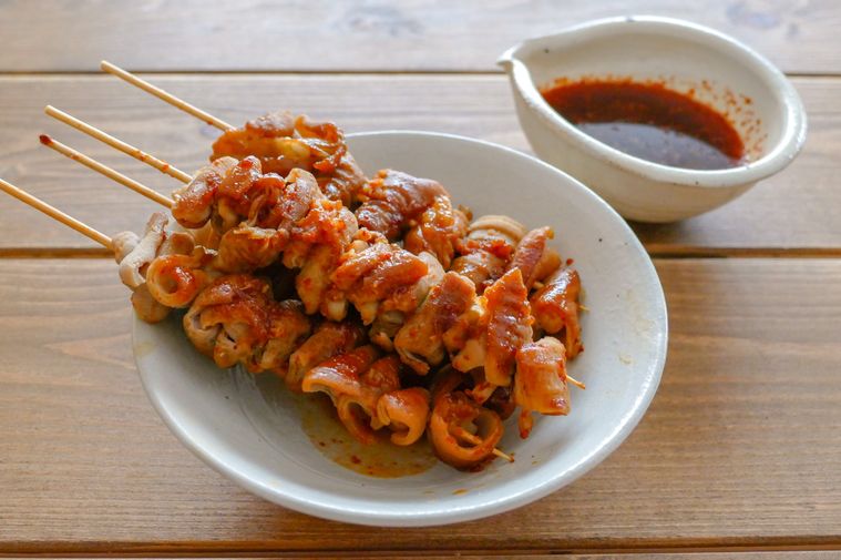 やまき風のタレをたっぷり絡ませた豚ホルモン串が盛られている白い器