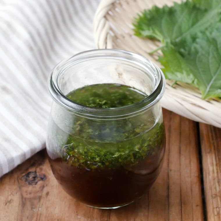 ガラスの容器に入った大葉ドレッシングとザルに並べられた大葉