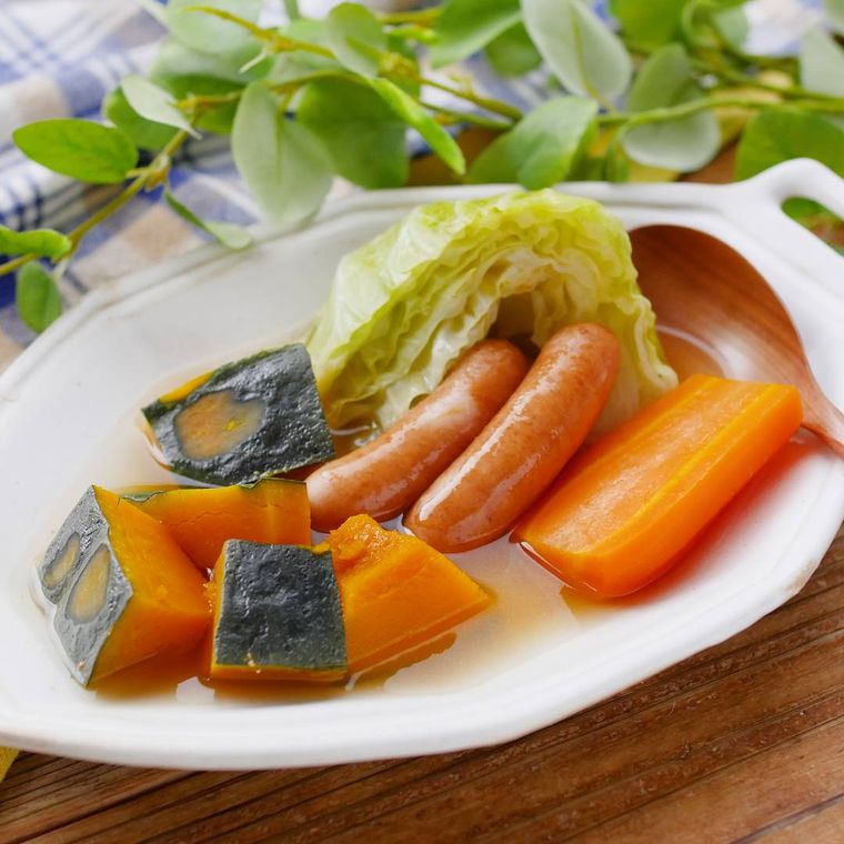 白い皿に盛られているかぼちゃとウインナーのポトフ