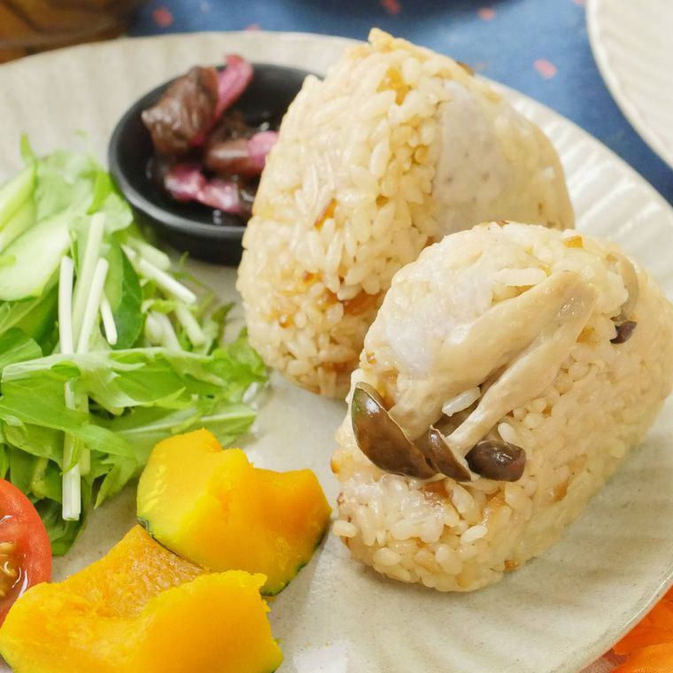 白い皿に盛られた里芋ときのこの炊き込みごはんとかぼちゃ、水菜