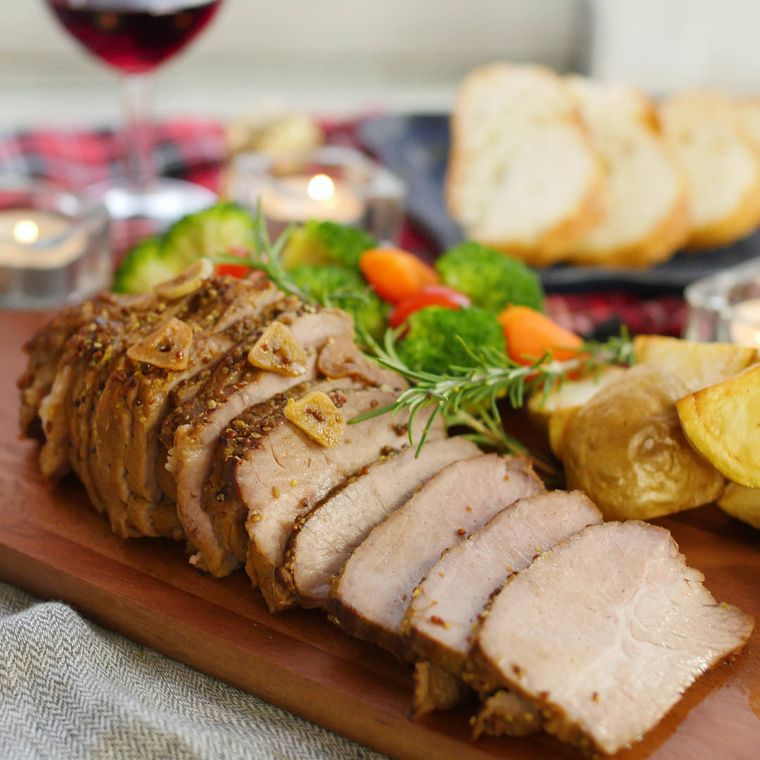 木製プレートに盛りつけカットされたフィレンツェ風豚肉のロースト
