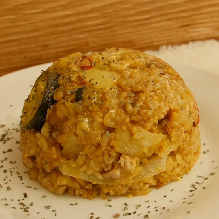 炊飯器で作った鶏胸肉と野菜のカレーピラフが白い皿に盛り付けられているところ