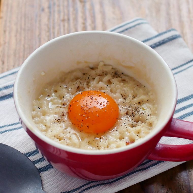 赤いマグカップに入っているカルボナーラ風のリゾットと卵黄
