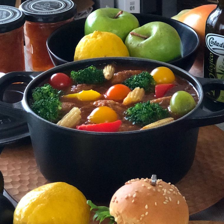 黒い鍋で煮込まれた豆腐ハンバーグシチュー