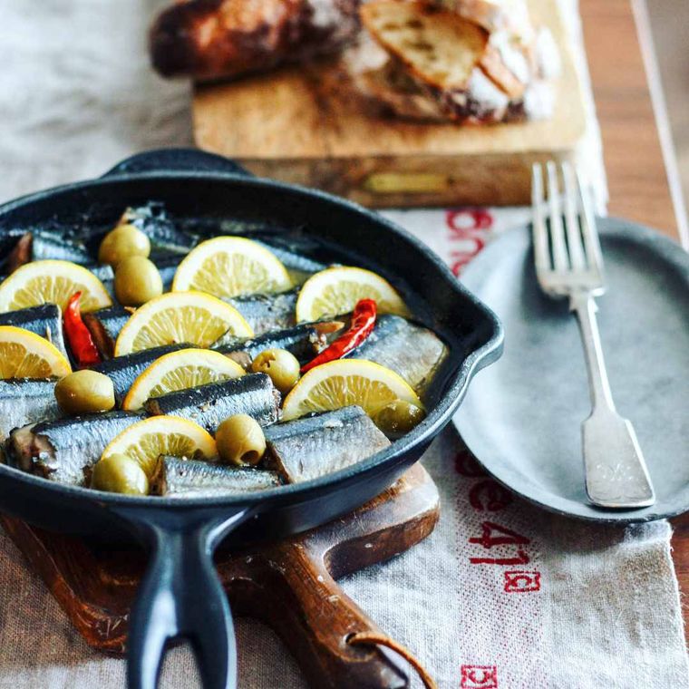 スキレットで作られたレモン風味の秋刀魚のアヒージョ
