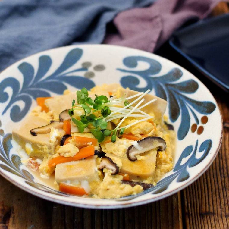 模様入りの皿に盛りつけられた高野豆腐とにんじん、しいたけの卵とじ