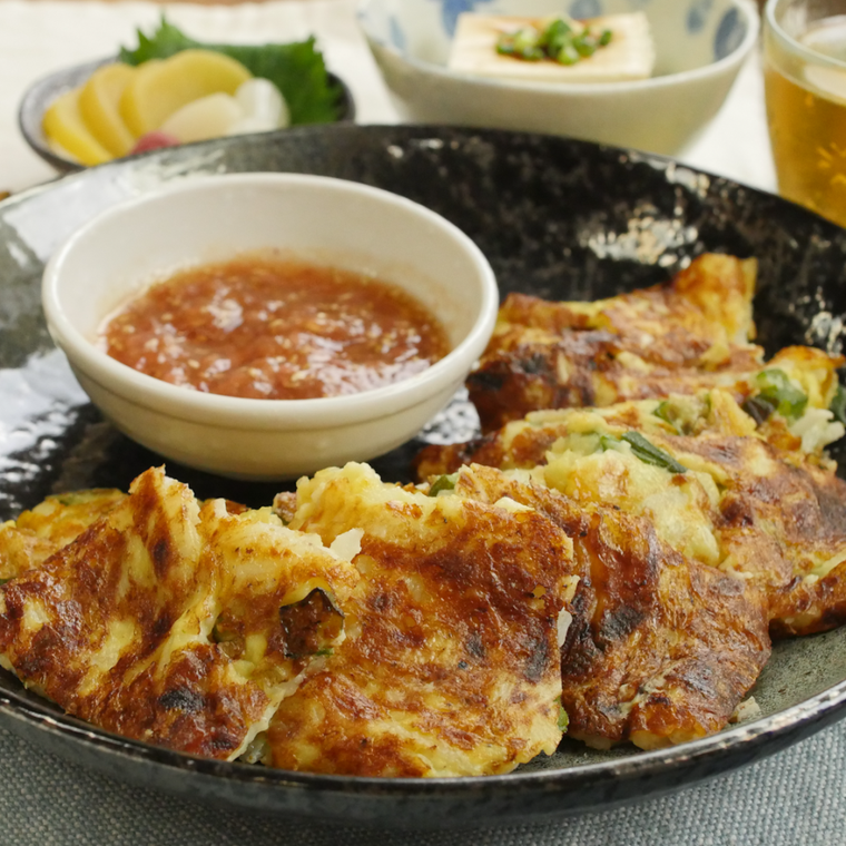 黒い器に盛り付けられた長芋とオクラのチーズチヂミ