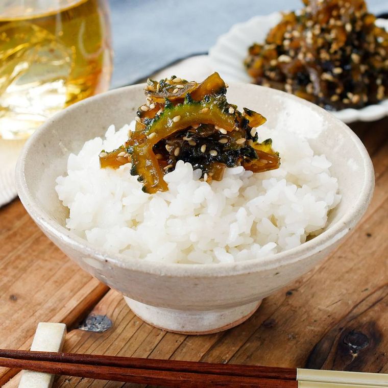 ベージュの飯椀に盛りつけられた白米とゴーヤの佃煮