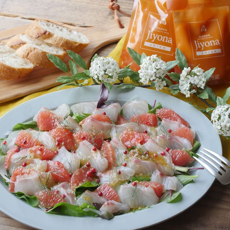 水色の皿に盛りつけられた、鯛とグレープフルーツのカルパッチョ