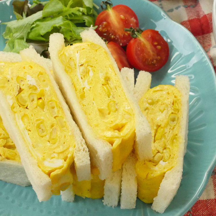 水色の皿に盛り付けられている生コーンの厚焼き卵サンド
