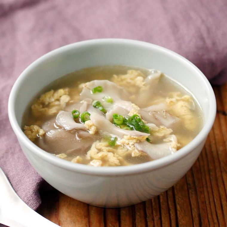 白いスープ碗に盛られた卵とまいたけの中華スープが机の上に置かれている