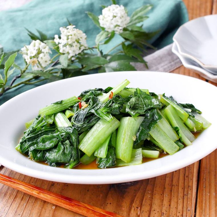 白いオーバル皿に盛り付けた、小松菜のごま油炒め