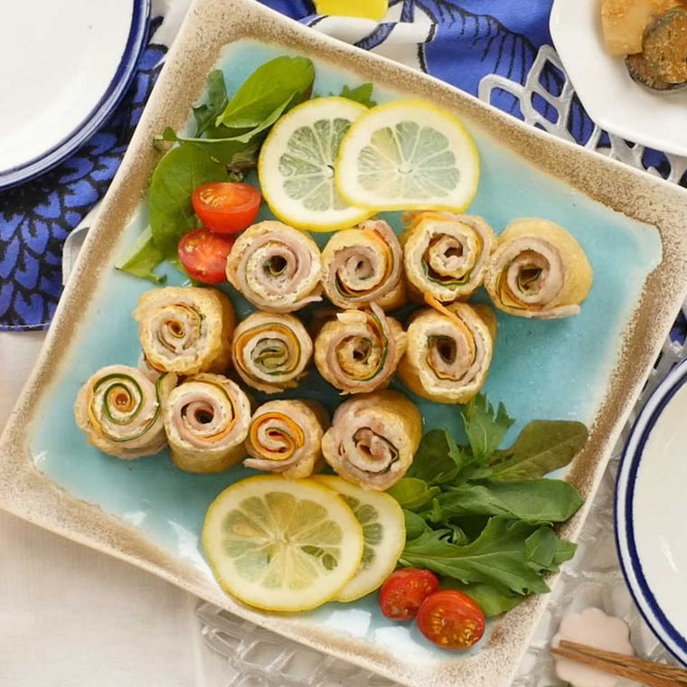 水色の皿に盛られた、 野菜と豚肉の油揚げ巻き