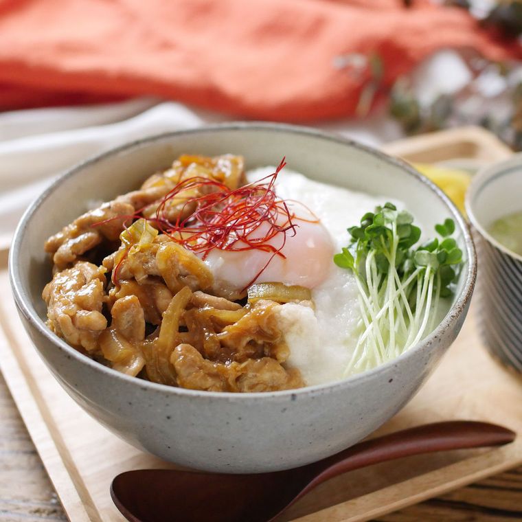 丼鉢に盛りつけられた豚こまと玉ねぎ、とろろのガリバタ温泉卵丼