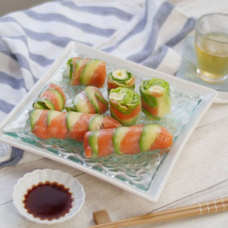 白い皿に盛られたサーモンとアボカドの生春巻き