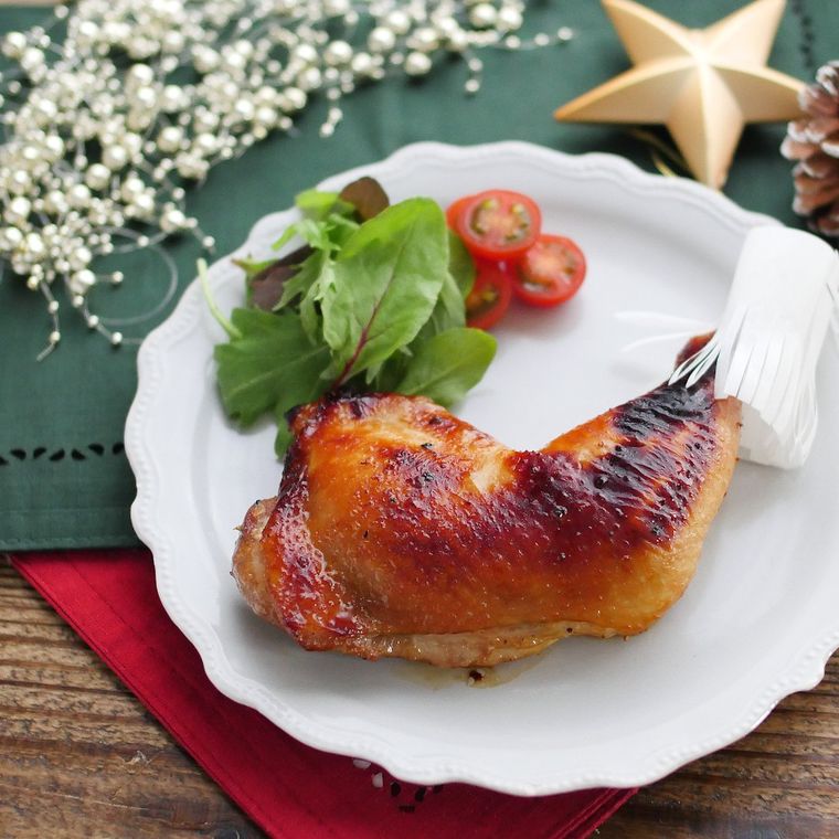 白い皿にのったローストチキンとサラダ