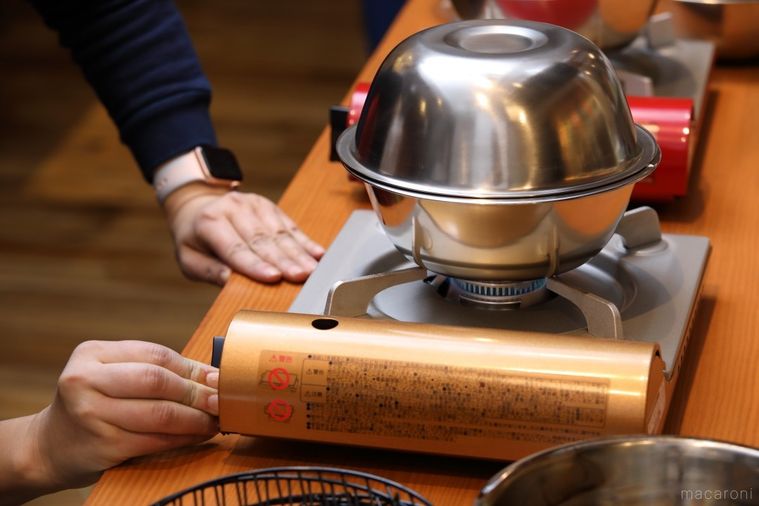 重ねたボウルがのったガスコンロの火を弱める様子