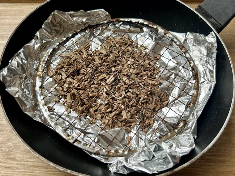 フライパンの底にアルミホイルを敷きその上にスモークチップを一握りと砂糖をのせたところ